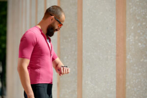 Side view of runner checking heart rate on fitness tracker when training outdoor.